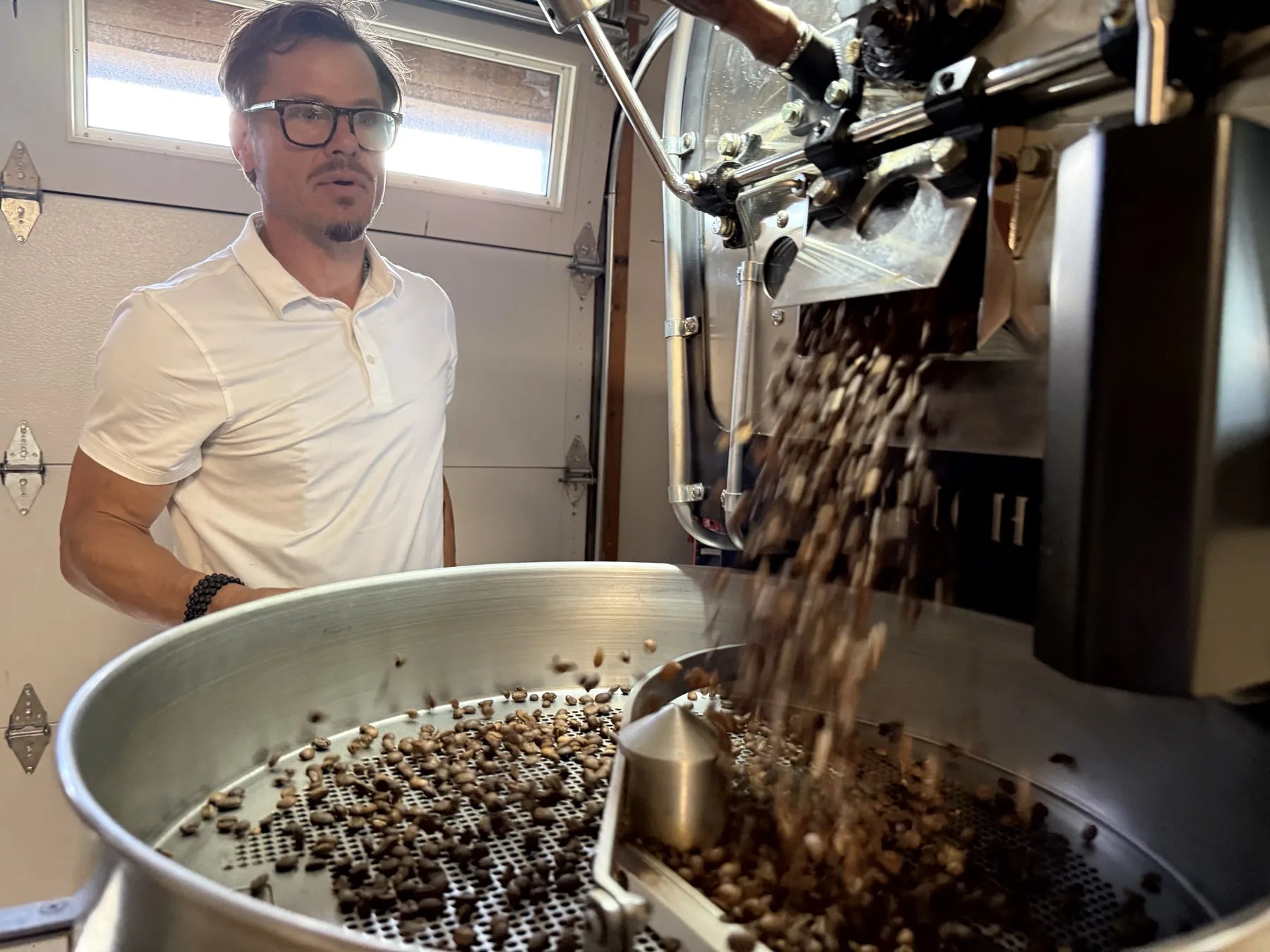 Freshly roasted beans dropping into the cooling tray