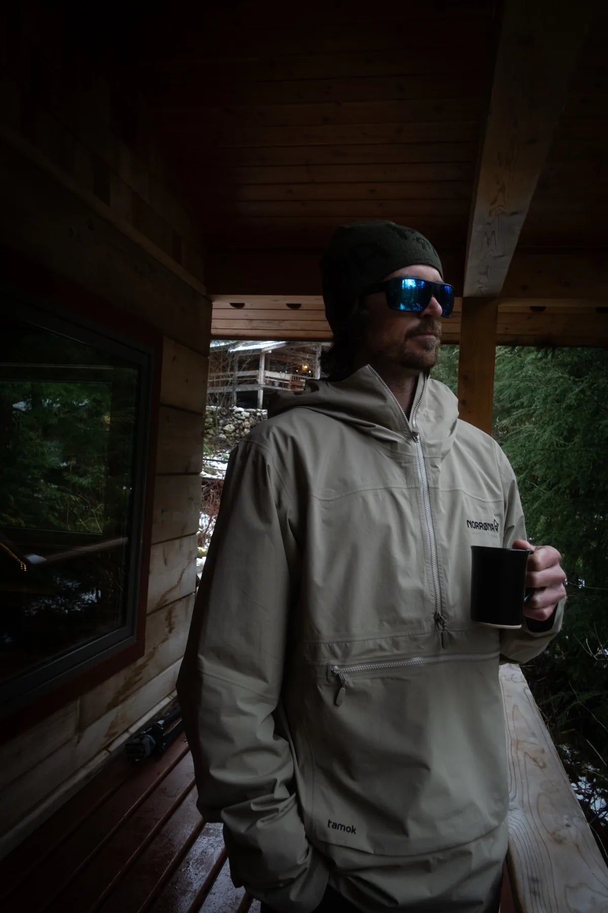 Skier on a lodge deck in British Columbia with a mug of coffee