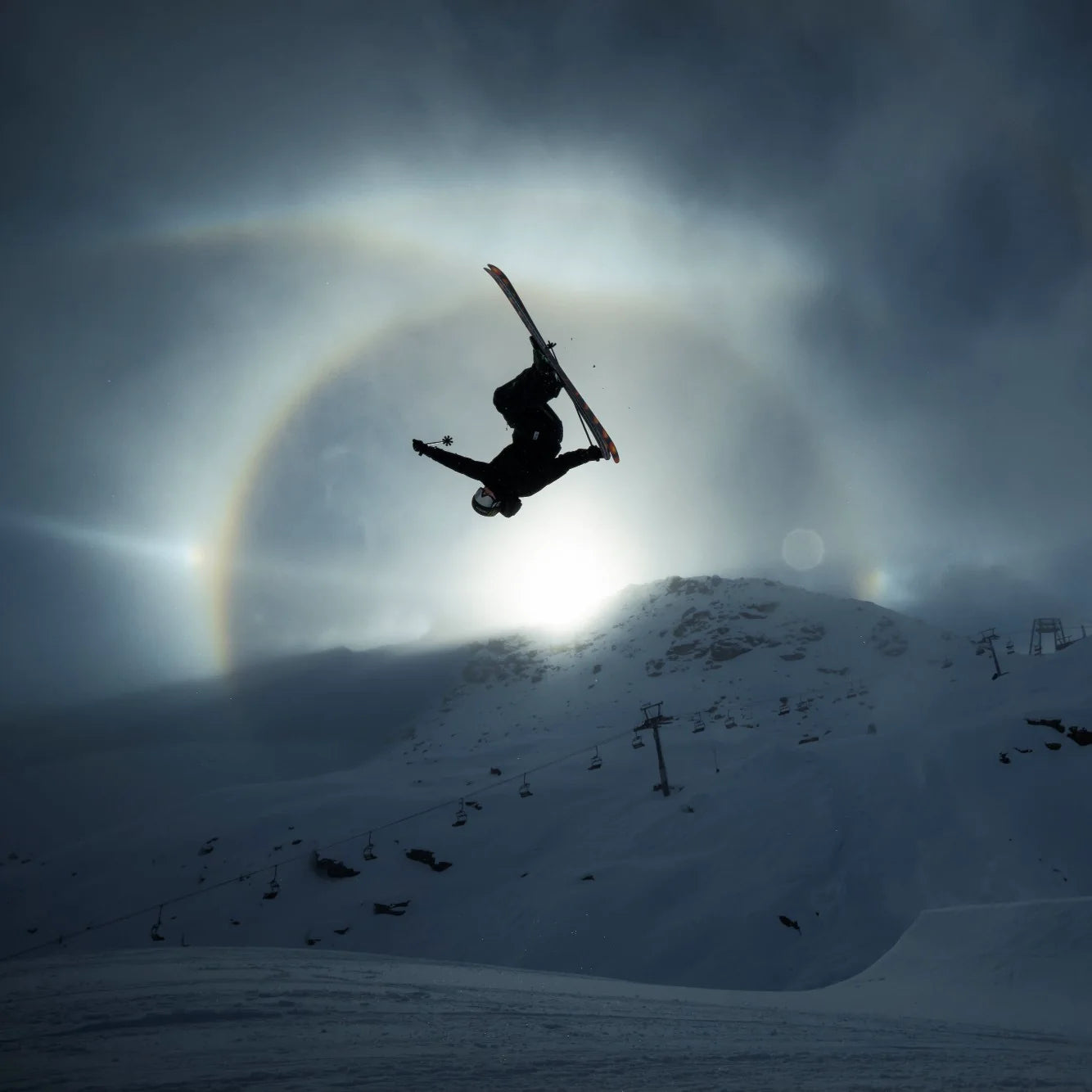 Colby Stevenson upside down mid-flip, silhouetted against a sun halo