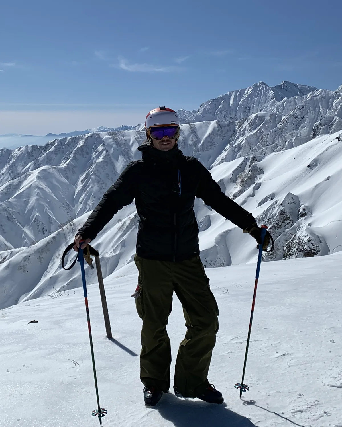 Mark, founder and roaster, on a snowy summit ridge with his ski poles