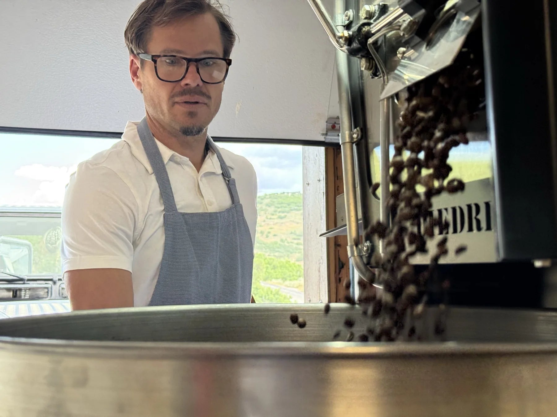Mark roasting, with the hills above Park City visible through the roastery door